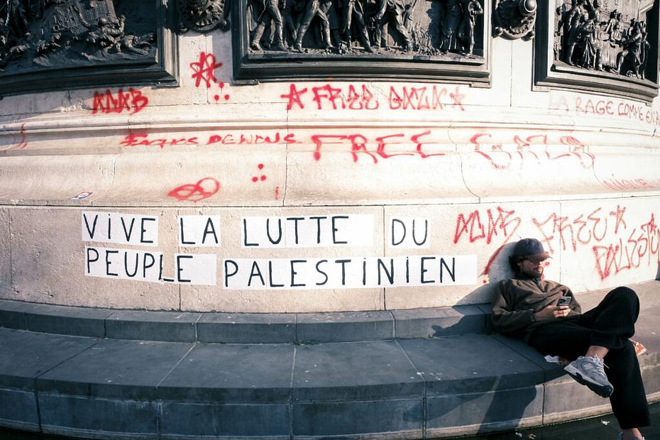 Manifestants assoupi a coté d'un mur où est collé l'inscription : "vive la lutte du peuple palestinien".