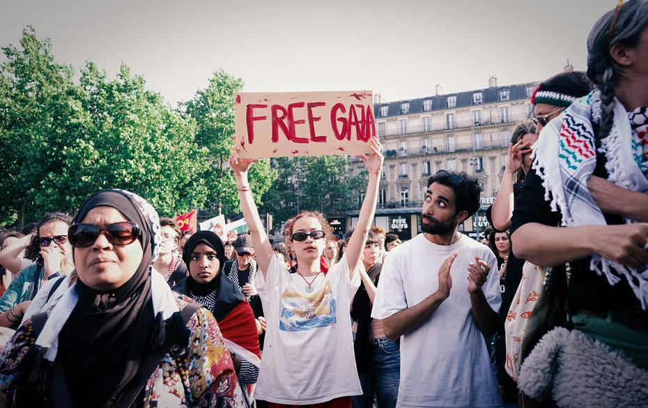 Jeune femme brandissant une pancarte "Free Gaza" au milieu d'une foule. 